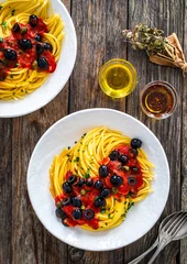 Spaghetti puttanesca with tomato sauce, anchovies, chili, capers and black olives on wooden table  © Jacek Chabraszewski