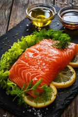 Fresh raw salmon steak with fresh vegetables on wooden background
