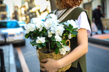 Woman Holding Basket of White Flowers