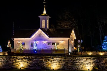 Quaint White Chapel Adorned With Twinkling Christmas Lights And Festive Decorations, Nestled...