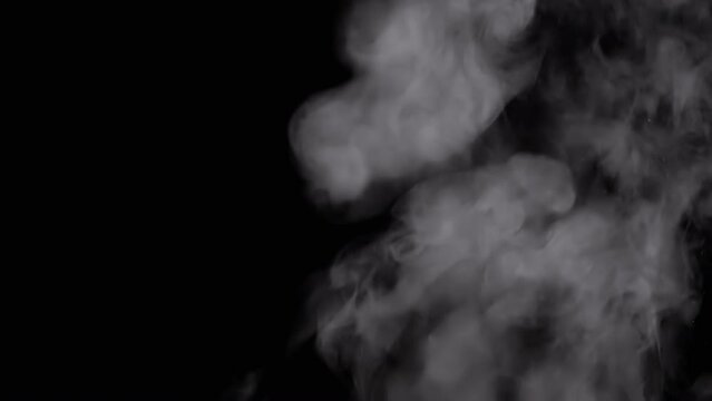 Thick Clouds of Steam with Drops of Water Rise Up and Dissolve in Empty Space. Side view. Black background. Texture. Abstract. Spraying. Exploding dynamic particles of water, smoke, cold fog. Blur.