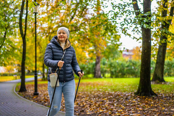 Nordic walking -  mid-adult woman exercising in city park
