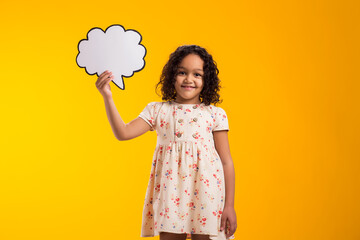 Smiling kid girl holding cloud bubble card. Dreaming concept