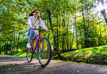 Mid-adult woman riding bicycle in city park
