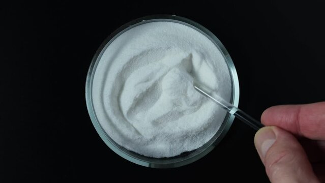 Sodium erythorbate or Sodium isoascorbate in Petri dish. Food additive E316 with chemical formula C6H7NaO6. White crystalline powder. Chemically, it is the sodium salt of erythorbic acid.
