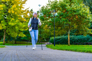 Nordic walking -  mid-adult woman exercising in city park
