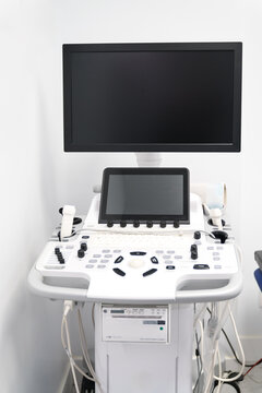 Sophisticated cardiology ultrasound machine with dual monitors and control panel in a clinical setting, ready for patient diagnostics