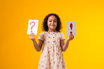 Smiling kid girl holding cards with question mark and exclamation point. Children, idea and...