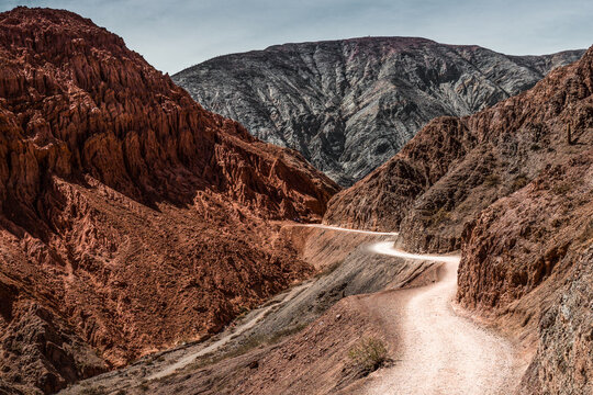 Curvy trail, in an impressive landscape of reddish minerals, in Purmamarca, Jujuy, northern Argentina. Tourism concept.