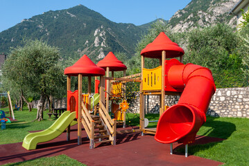 Parco giochi per bambini con scivolo e casette di legno