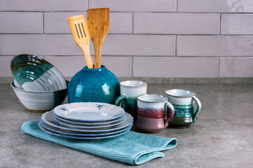 View of the kitchen table with ceramics dishware and blue towel. - 732675740