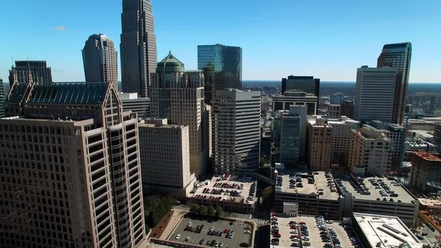 Aerial Shot Of Modern Office Towers In Financial District, Drone Flying Forward Over Cars In Parking Lot On Sunny Day - Charlotte, North Carolina
