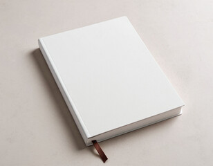 Minimalistic white hardcover book with a brown ribbon bookmark on a neutral background, highlighting simplicity and elegance in design.