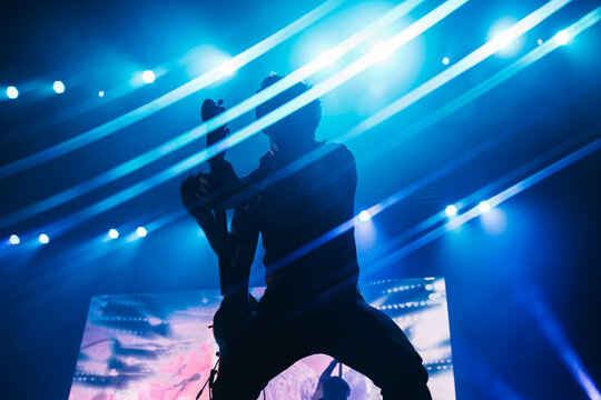 Silhouette of a bass guitar player in a background full of lights