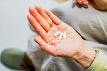 手のひらの薬をのせる女性