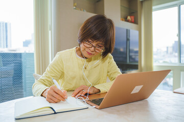 ノートパソコンで研修を受けるシニア女性