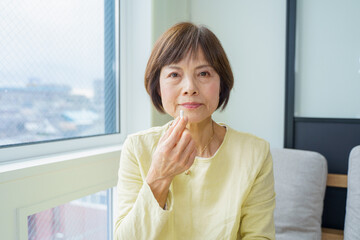 薬を手に持つシニア女性