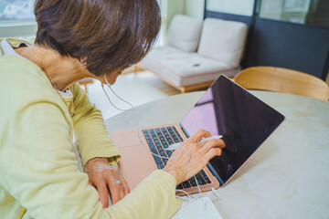 パソコンでリモートワークするシニア女性