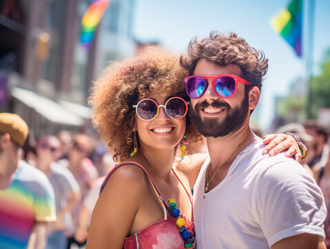 photo of couple at pride parade, stopped posing for camera, celebration of love on a sunny day