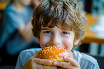 young boy eating hamburguer
