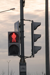 Red traffic light and road signs against the sky