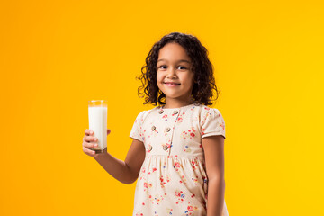 Smiling child girl holding glass of milk. Nutrition and health concept