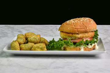 salmon burger on sesame bun with veggie tots,