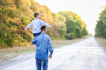 Obraz premium A Happy parent with a child in the park hands on nature travel go along the road