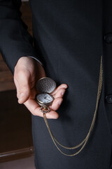 a pocket watch in the hands of a man