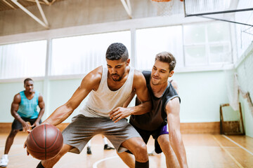 Basketball players playing basketball in an indoor basketball gym