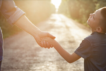 A Hands of a happy parent and child in nature in the travel park