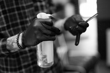 a hairdresser in a barbershop disinfects a razor with a spray