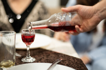 a waiter in a restaurant pours alcohol into a glass at the table