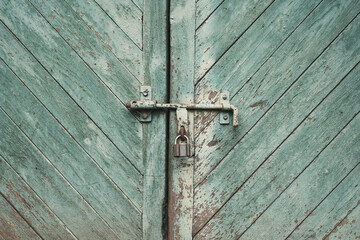old metal lock on a wooden door with cracked paint