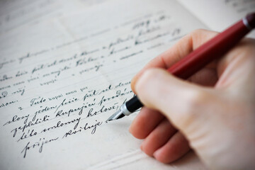 Close-up of a Caucasian female hand holding a fountain pen and writing a purchase contract in Czech language. Concept for old law, legal issues and old handwritten documents. - obrazy, fototapety, plakaty