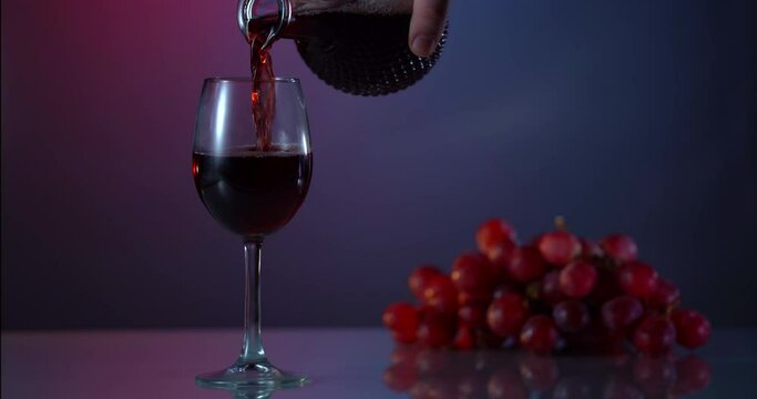 Red wine forms beautiful wave. Wine pouring in wine glass over white background. Close-up shot. Slow motion of pouring red wine from bottle into goblet. advert shot. Alcohol advertising packshot