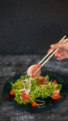 Seafood salad served on a beautiful plate. Salad with king prawns and prosciutto.
