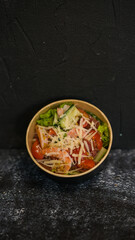 Seafood salad served on a beautiful plate. Salad with king prawns and prosciutto.
