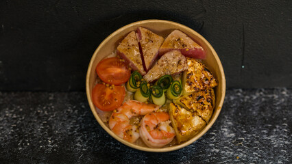Seafood salad served on a beautiful plate. Salad with king prawns and prosciutto.