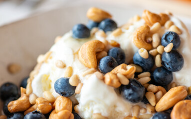 Beautiful breakfast - ice cream, berries cashew, cedar, blueberry and honey in the plate. Good morning. Macro - 732725513