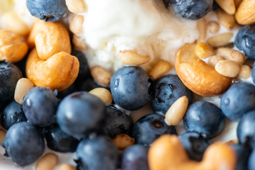 Beautiful breakfast - ice cream, berries cashew, cedar, blueberry and honey in the plate. Good morning. Macro - 732725733