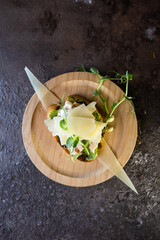 Close-up Appetizing open faced sandwich with chicken and cheese on wooden plate with dark background