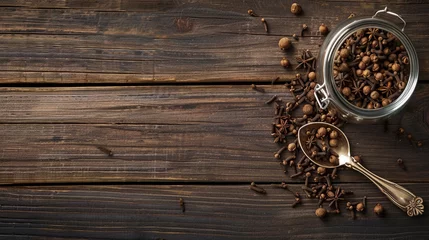 Tuinposter a jar of cloves and spices on a wooden table © Vahagn