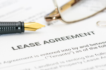 Business legal document concept : Pen and glasses on a lease agreement form. Lease agreement is a contract between a lessor and a lessee that allow lessee rights to use of a property owned by lessor. - obrazy, fototapety, plakaty