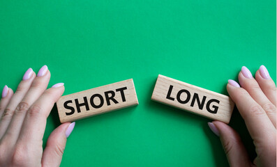 Short vs Long symbol. Concept word Short vs Long on wooden blocks. Businessman hand. Beautiful...