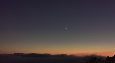 Luna sopra le nuvole nel cielo scuro al tramonto