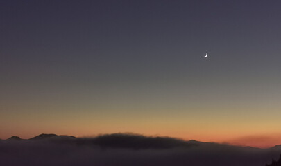Naklejka na ściany i meble Luna sopra le nuvole nel cielo scuro al tramonto