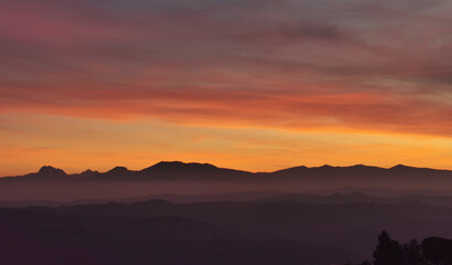 Il cielo rosso di nuvole sopra le montagne al tramonto