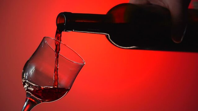 Pouring Red Wine into a Glass on the beautiful Background. advertising shot. adver alcohol