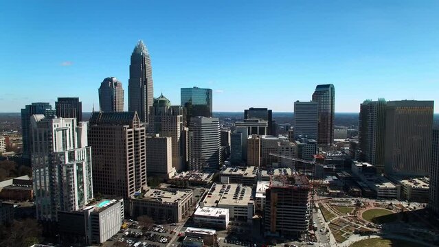 Aerial Backward Shot Of Downtown District In Residential City Against Clear Sky On Sunny Day - Charlotte, North Carolina